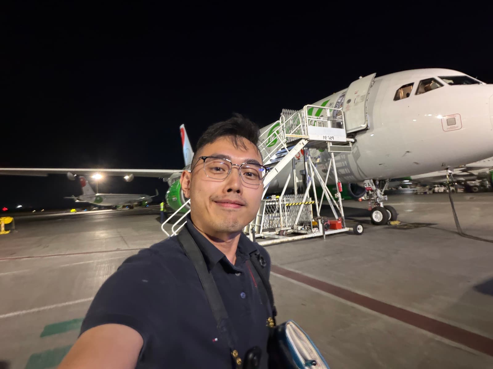 Carter on the apron beside an aircraft at night