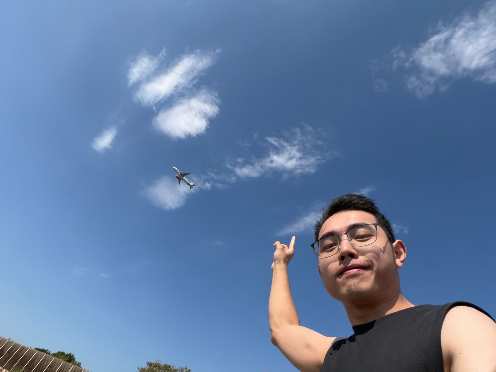 Carter pointing toward an aircraft in the blue sky